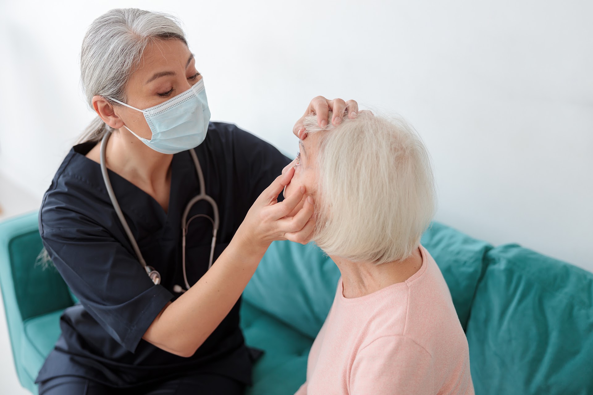 An eye examination with an older woman seated on a sofa